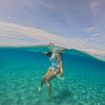 A Girl Floating inside water in the white sandy backround