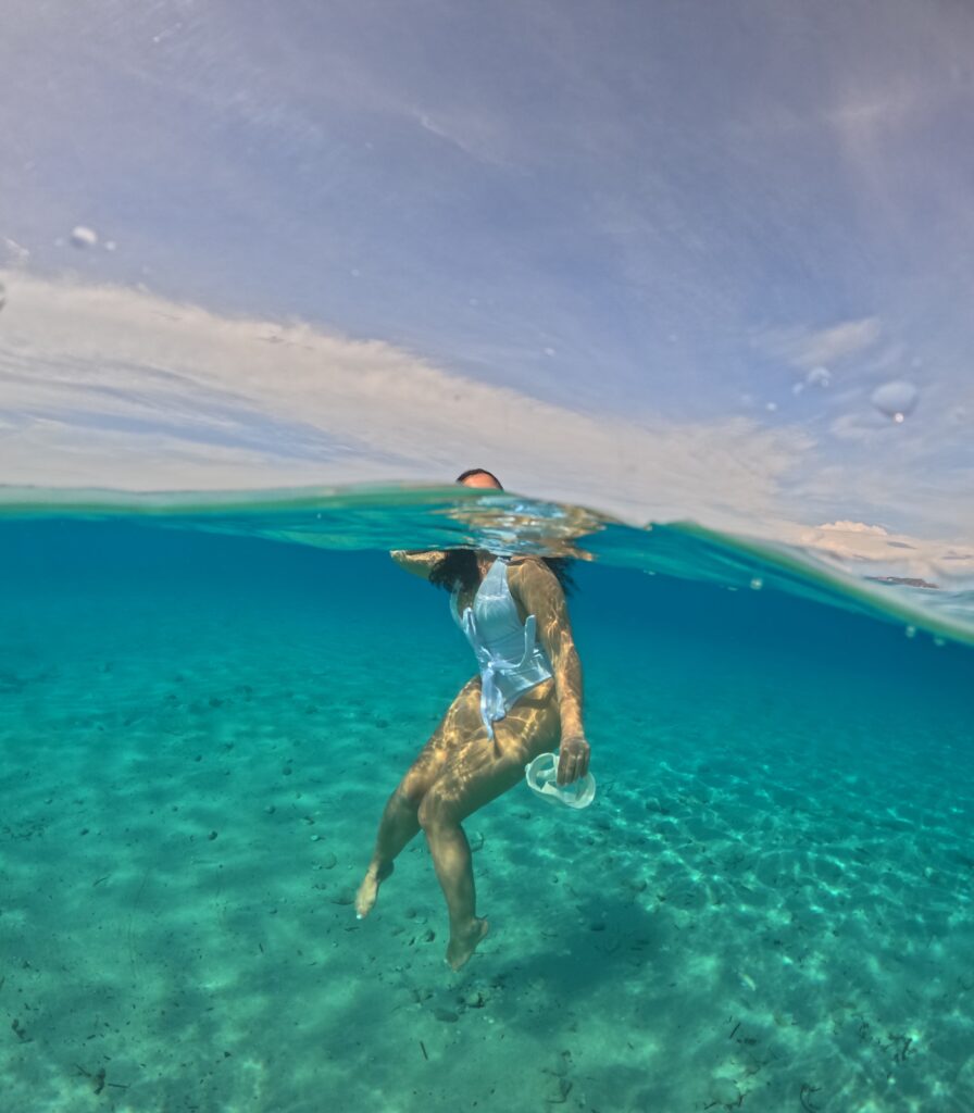 A Girl Floating inside water in the white sandy backround