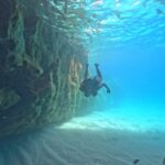 a girl dives into an underwater cave