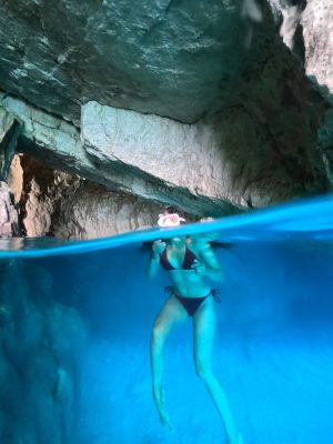 a girl dives into an underwater cave